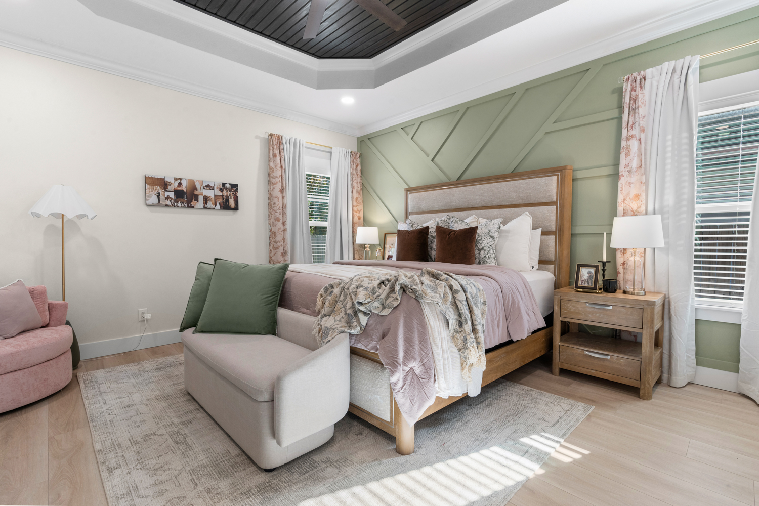 Styled bedroom with upholstered bench, patterned drapery and warm layered textiles