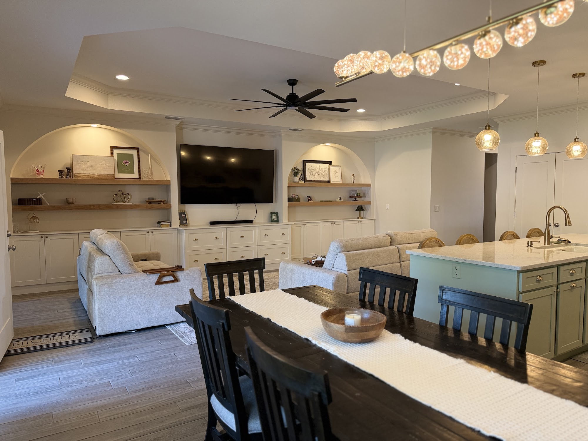 Open plan living and dining with a long timber table, upholstered seating and a vaulted ceiling