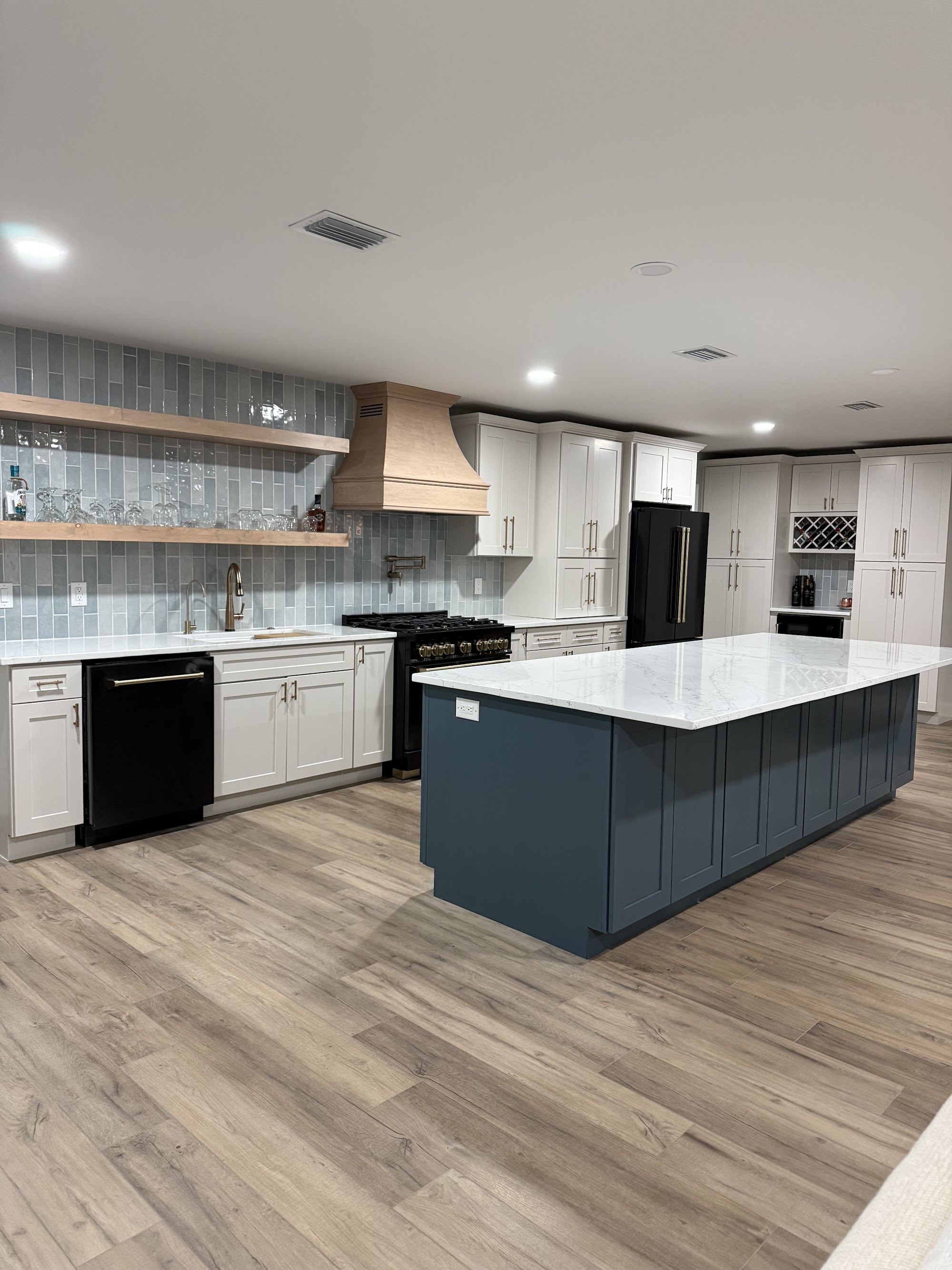 Kitchen with navy island, quartz counters and brass hardware