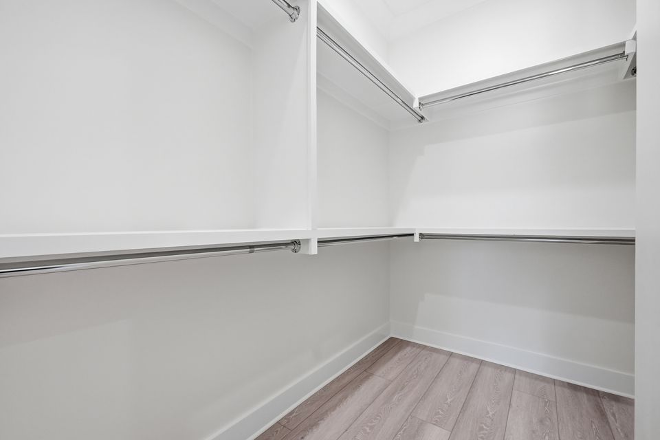 Walk-in closet fitted out with hanging rails and shelving along two walls