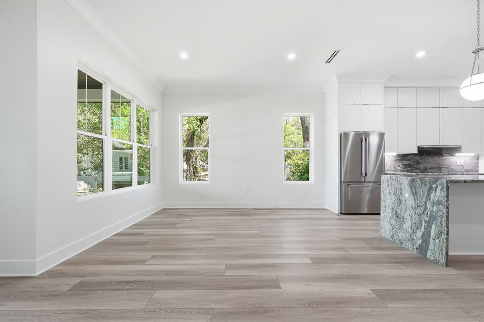 Dining area open to the kitchen, with pendant lighting and windows along one wall